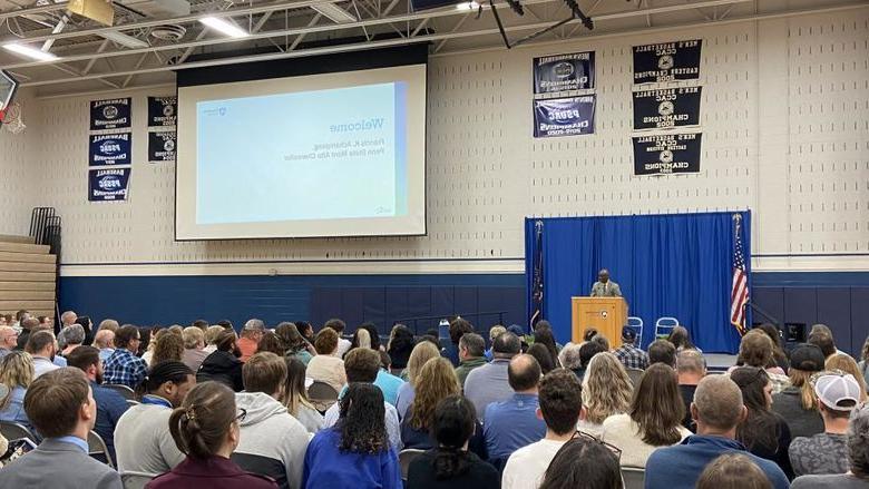 Penn State Mont Alto Chancellor stands at the podium while a crowd sits in the audience watching