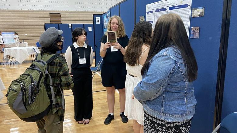 Students stand around a display at the Academic Festival